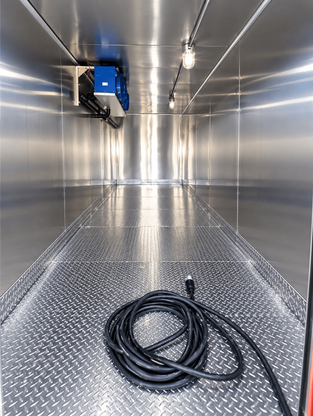 Refrigerated trailer interior with a coiled power cable on the metal floor