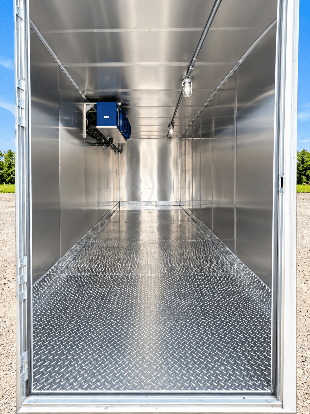 Open refrigerated storage interior with a blue cooling unit and diamond-plate floor