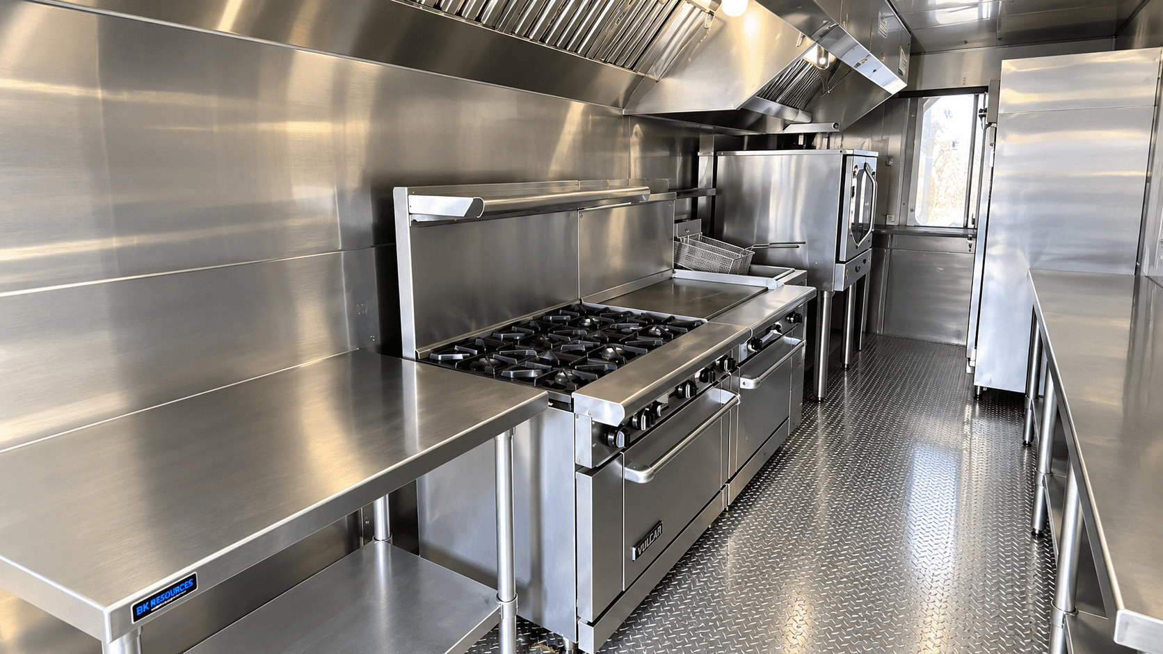 Commercial kitchen cooking line with range, griddle, fryer and ovens