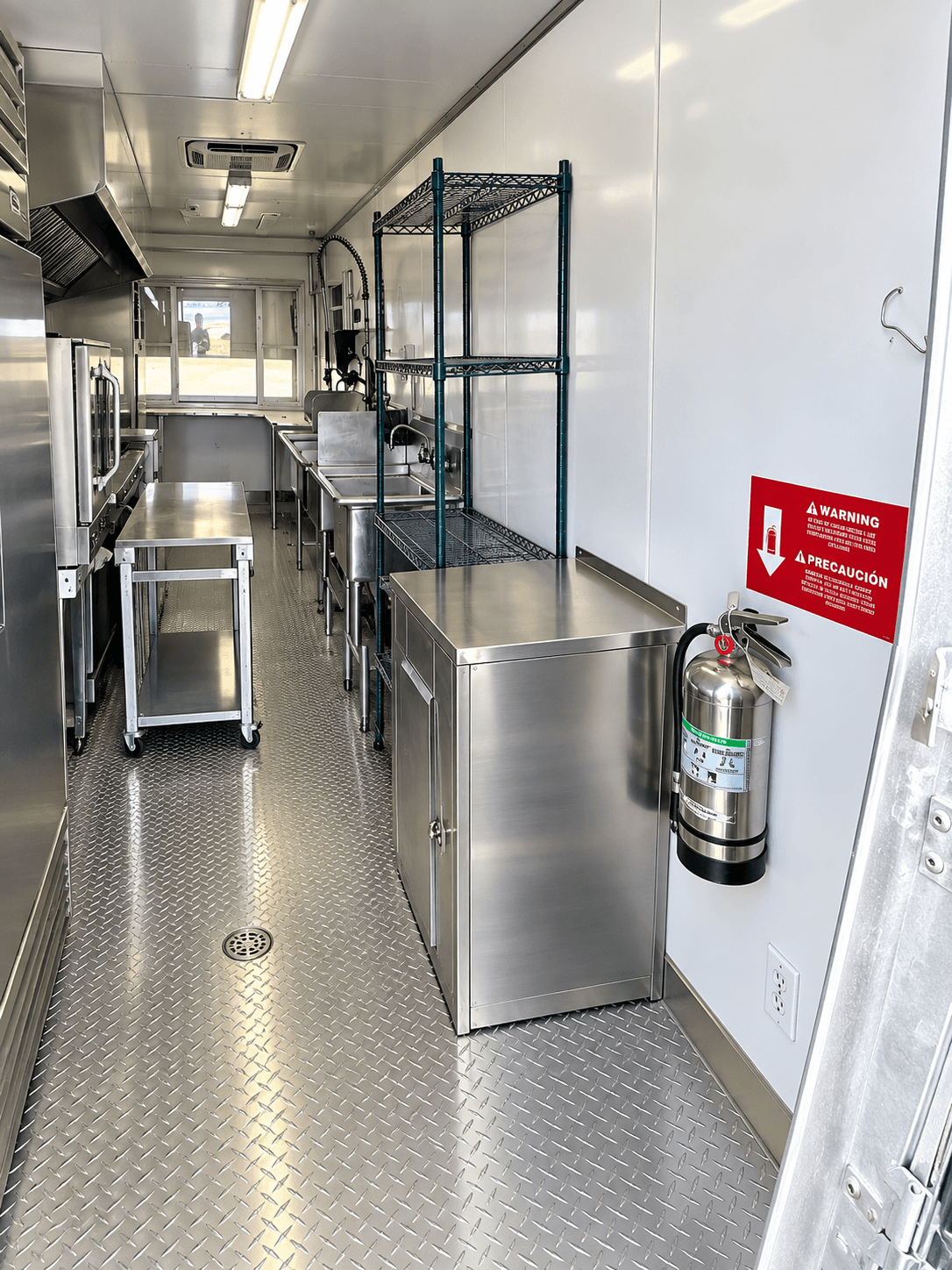 Mobile kitchen aisle with stainless work counters and storage shelving